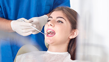 Dentist examining female patient in chair