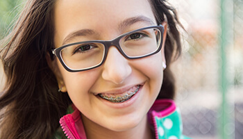 Smiling young girl wearing traditional braces in Danville