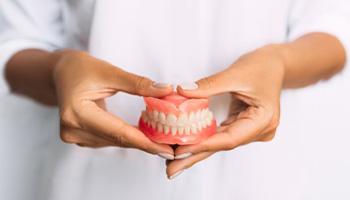 Lady presents viewer with dentures