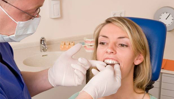 Dentist fitting woman with clear aligner