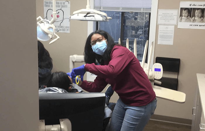 Dental volunteer displaying model teeth to kids