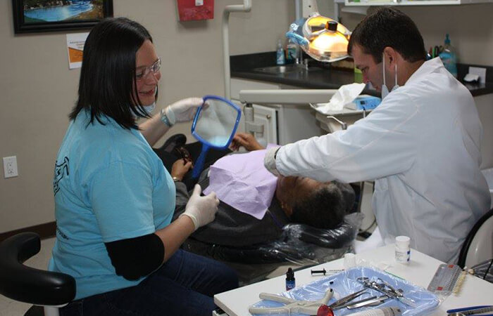 Dr. Payne and assistant working on elderly patient