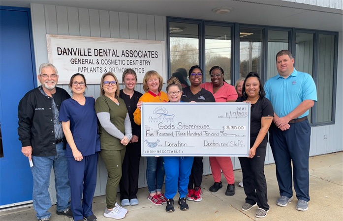 Dentists and their team of dental volunteers in orange shirts