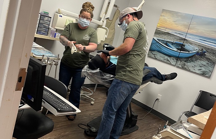 Dentists and their team of dental volunteers in orange shirts