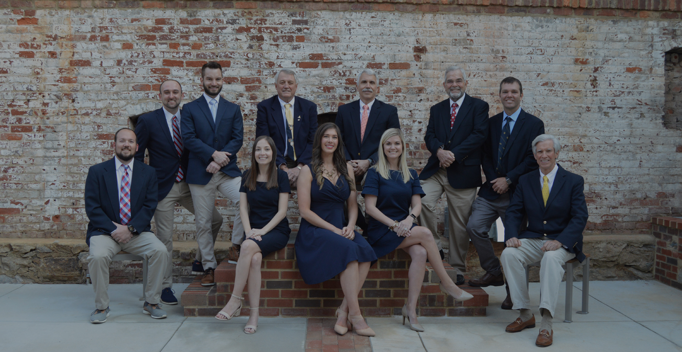 Danville dentists and dental team members in front of a brick wall