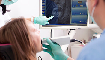 Dentist and patient looking at images captured by intraoral camera