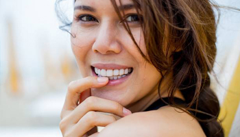 Woman smiling while touching her chin