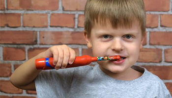 Young boy using an electric toothbrush to brush his teeth