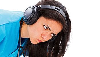 Woman looking frustrated while wearing headphones