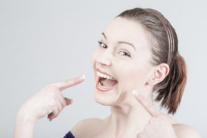 woman pointing at teeth