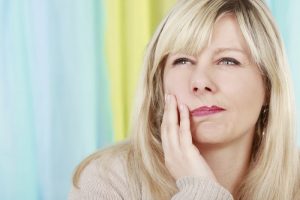 woman holding jaw in pain