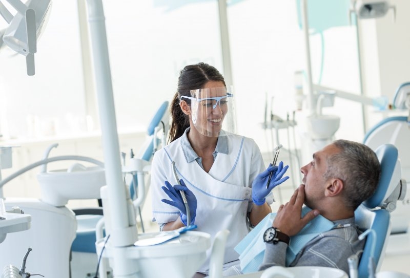 Dentist wearing PPE while talking to patient