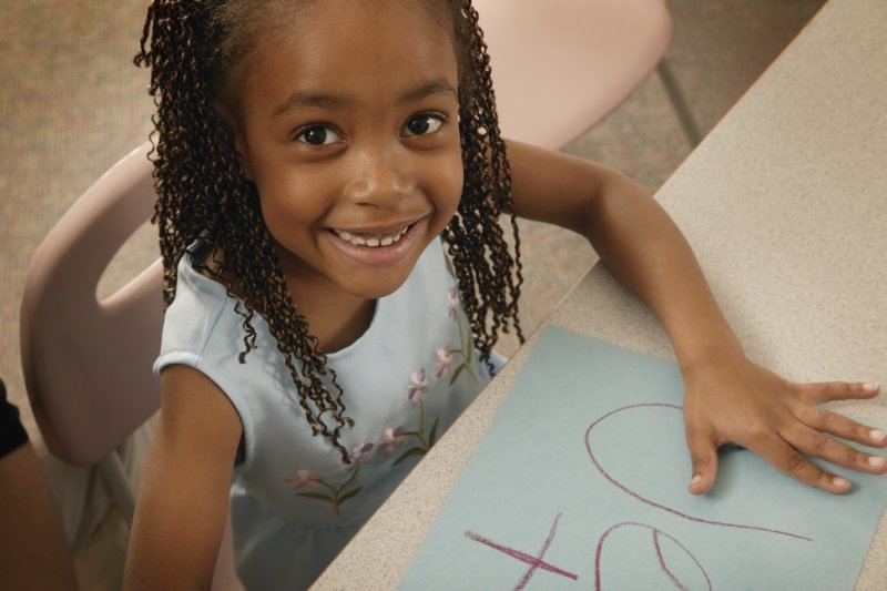 young girl in school coloring a picture