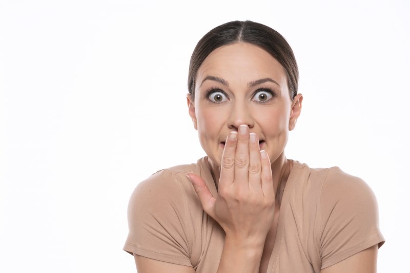 woman covering teeth from a dentist in Danville