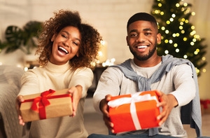 Smiling couple holding gifts during the holiday season