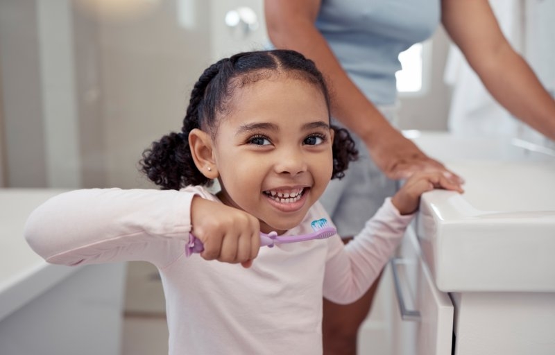 a little girl brushing her teeth